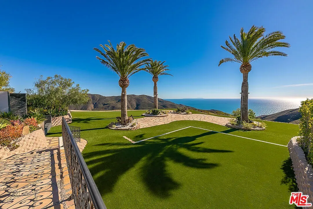 Coastal lawn is golf-course perfect. Palm silhouettes, ocean peeking. Unreal.