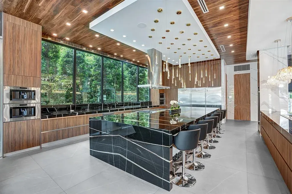 Dark wood kitchen with a glossy black island. Veining looks lightning.