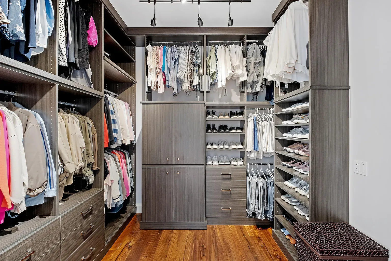 Dark wood closet looking boutique-level organized. Shelves for days.