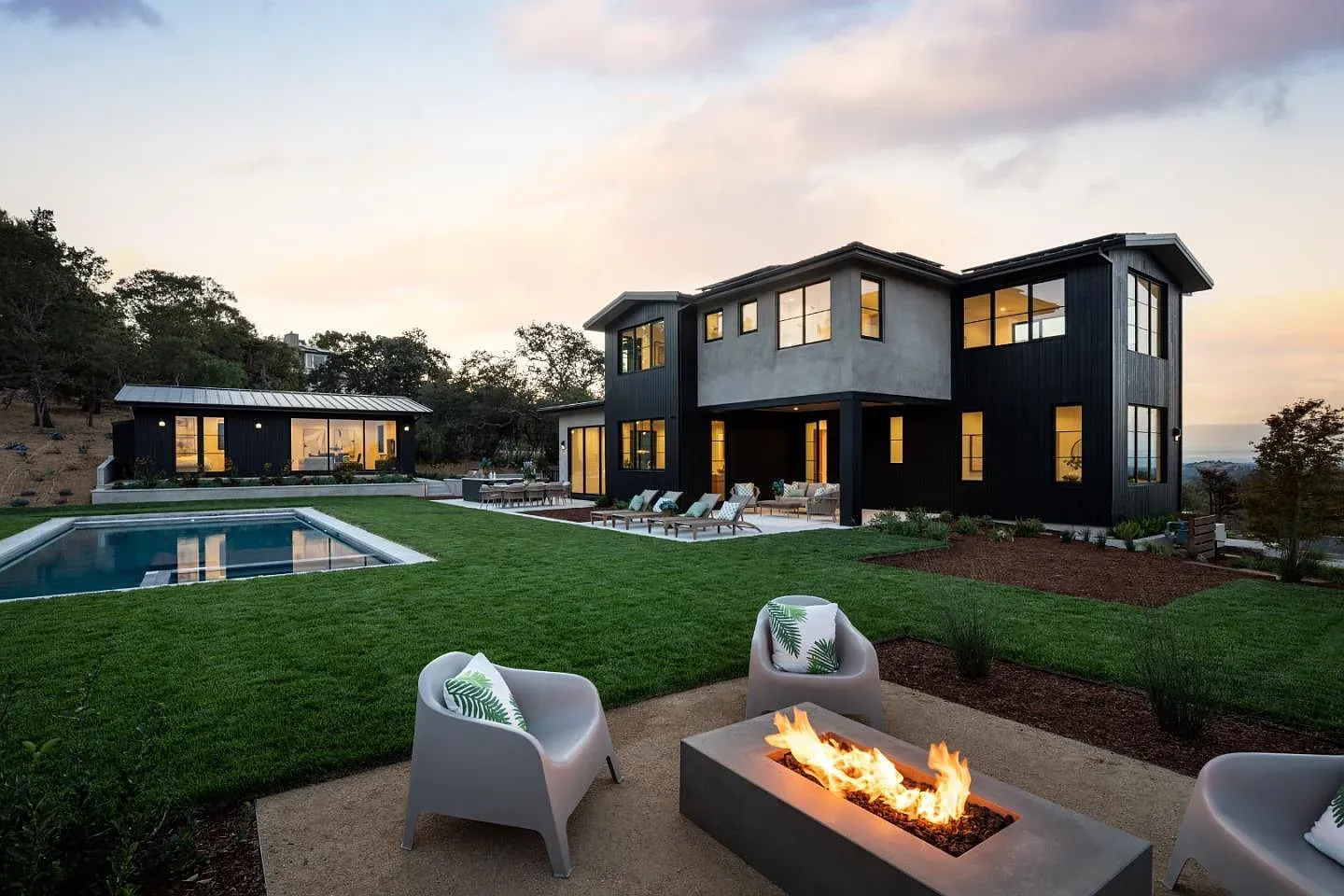 Backyard pool, clean rectangle, surrounded by grass. Dark exterior makes it pop.