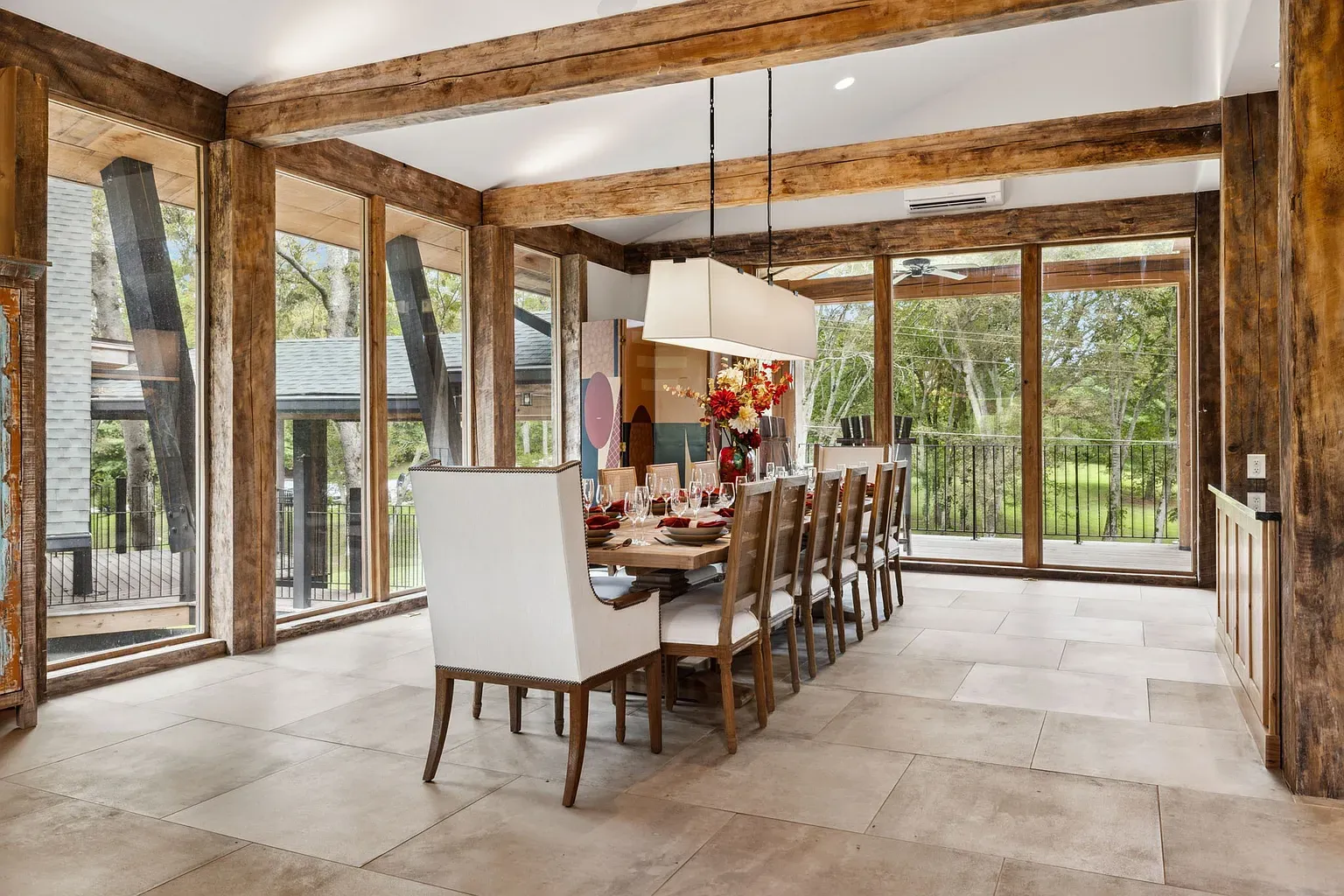 Formal dining but still warm. Long slab table, comfy chairs, big dinner party energy.