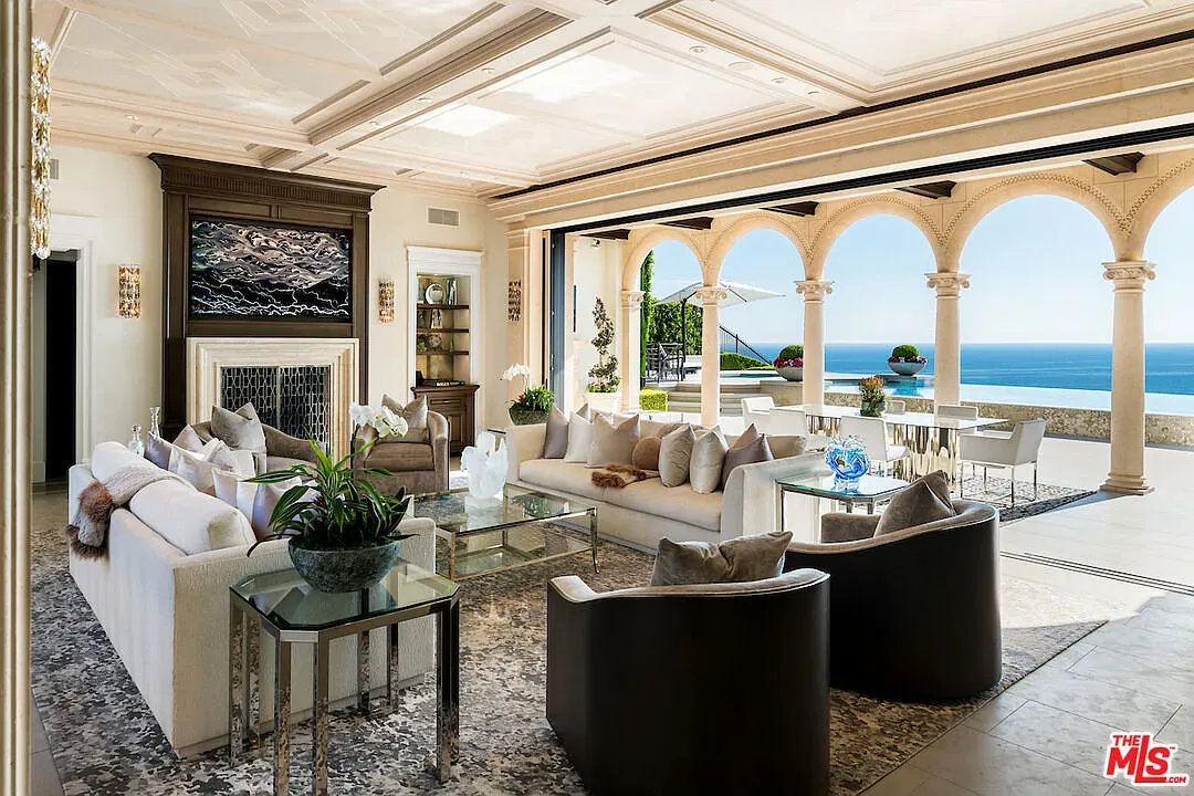 Light living room—cream sofas, glass table, gentle blues. Airy without feeling empty.