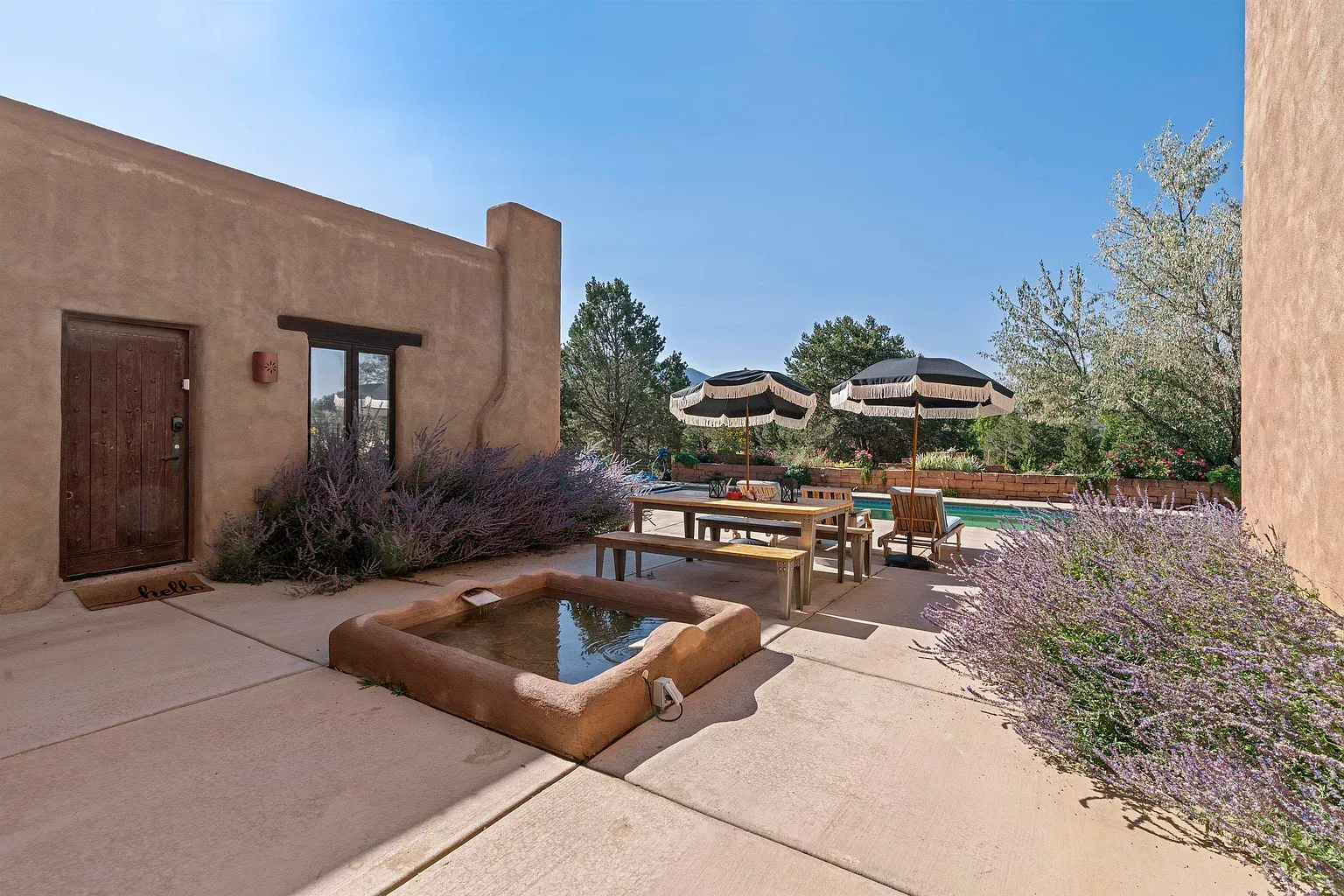 Rustic door in a tan adobe wall. Feels a quiet little courtyard.