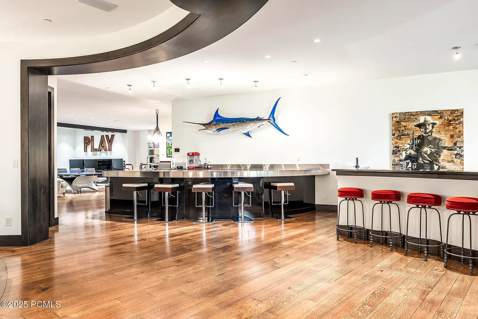 Open layout with honey floors. Sleek focal wall—TV or bar? Looks fun.