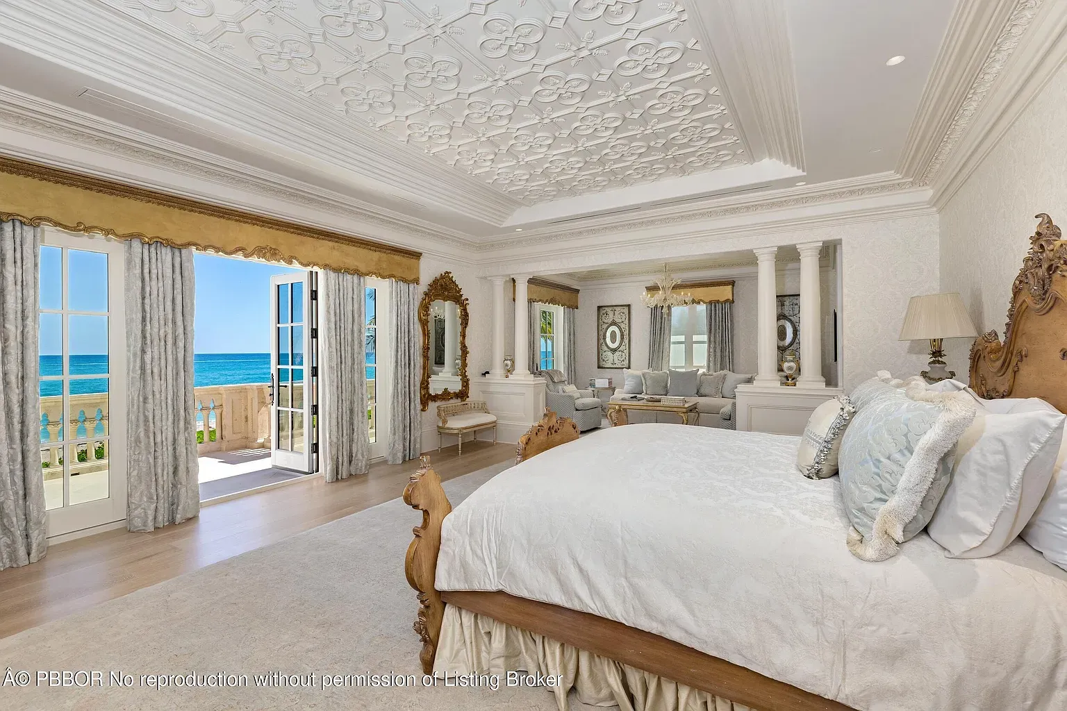 Coastal bedroom in creams and pale blues. Carved bed steals attention.