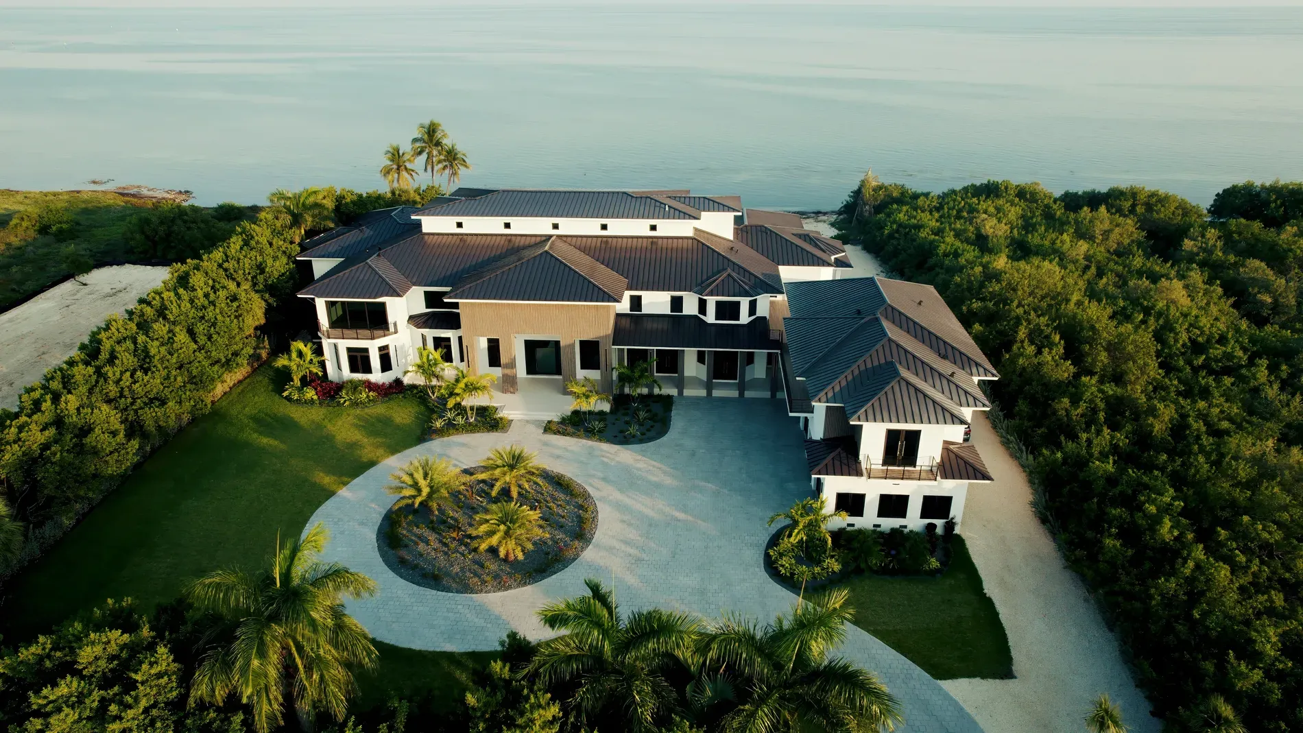 Sleek coastal box, white and charcoal. Looks calm tucked into all that green.