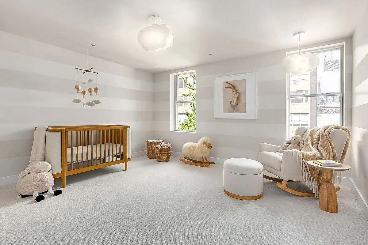 Nursery in soft stripes. Calm, airy, very new-parent Pinterest.