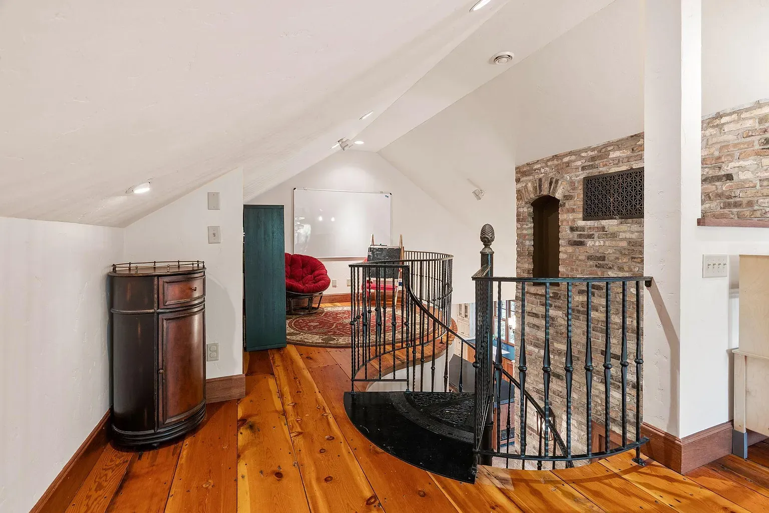 Spiral staircase moment. Loft feels bigger because of that slope and light.