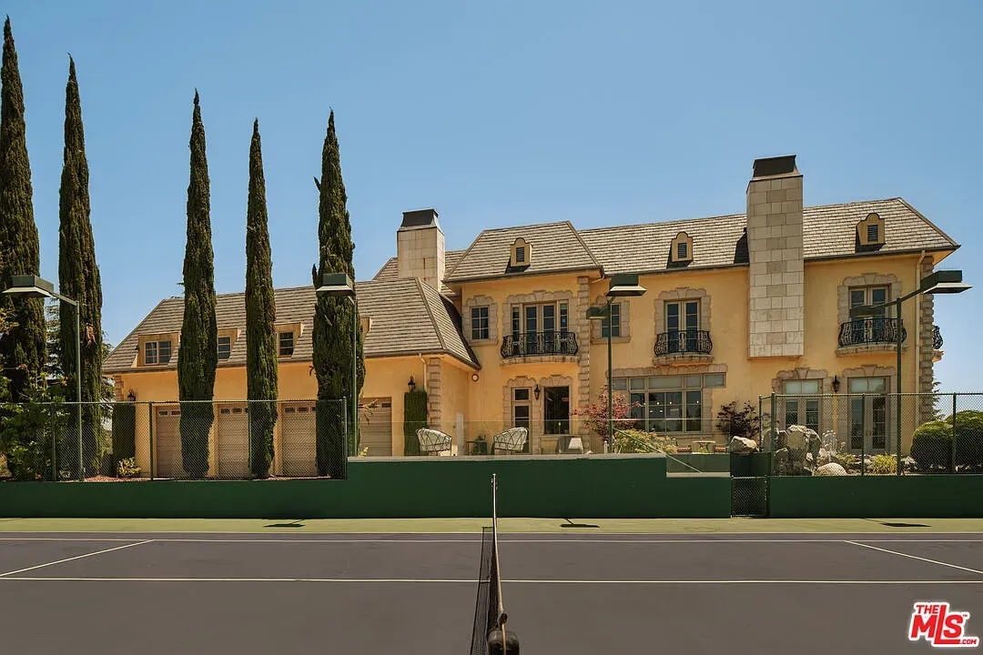 Final shot. sunny yellow villa with iron balconies and cypress. Classic postcard energy.