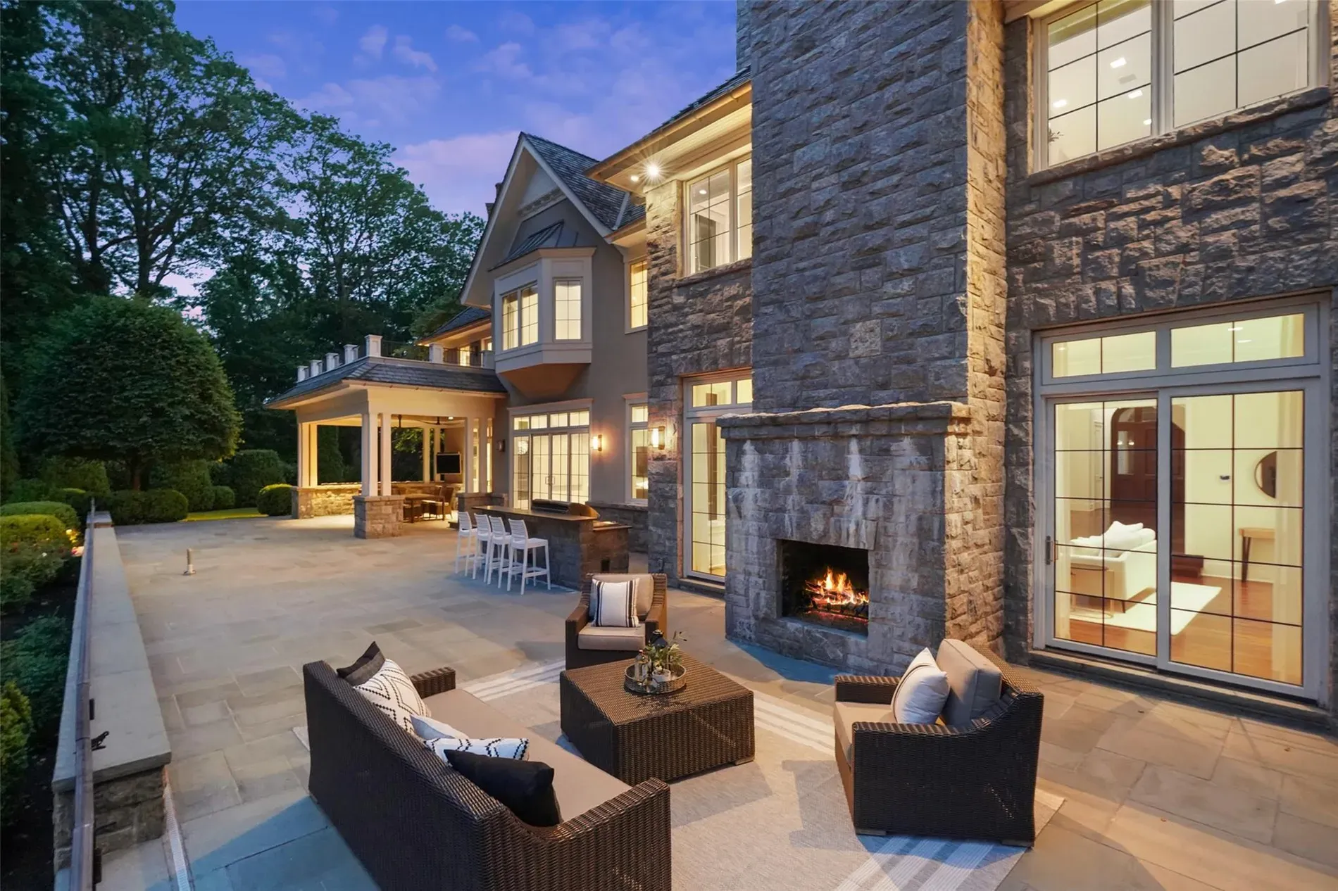 Back outside—flagstone patio, dark wicker, fireplace ready. Feels weekend-proof. This angle hides the grill?