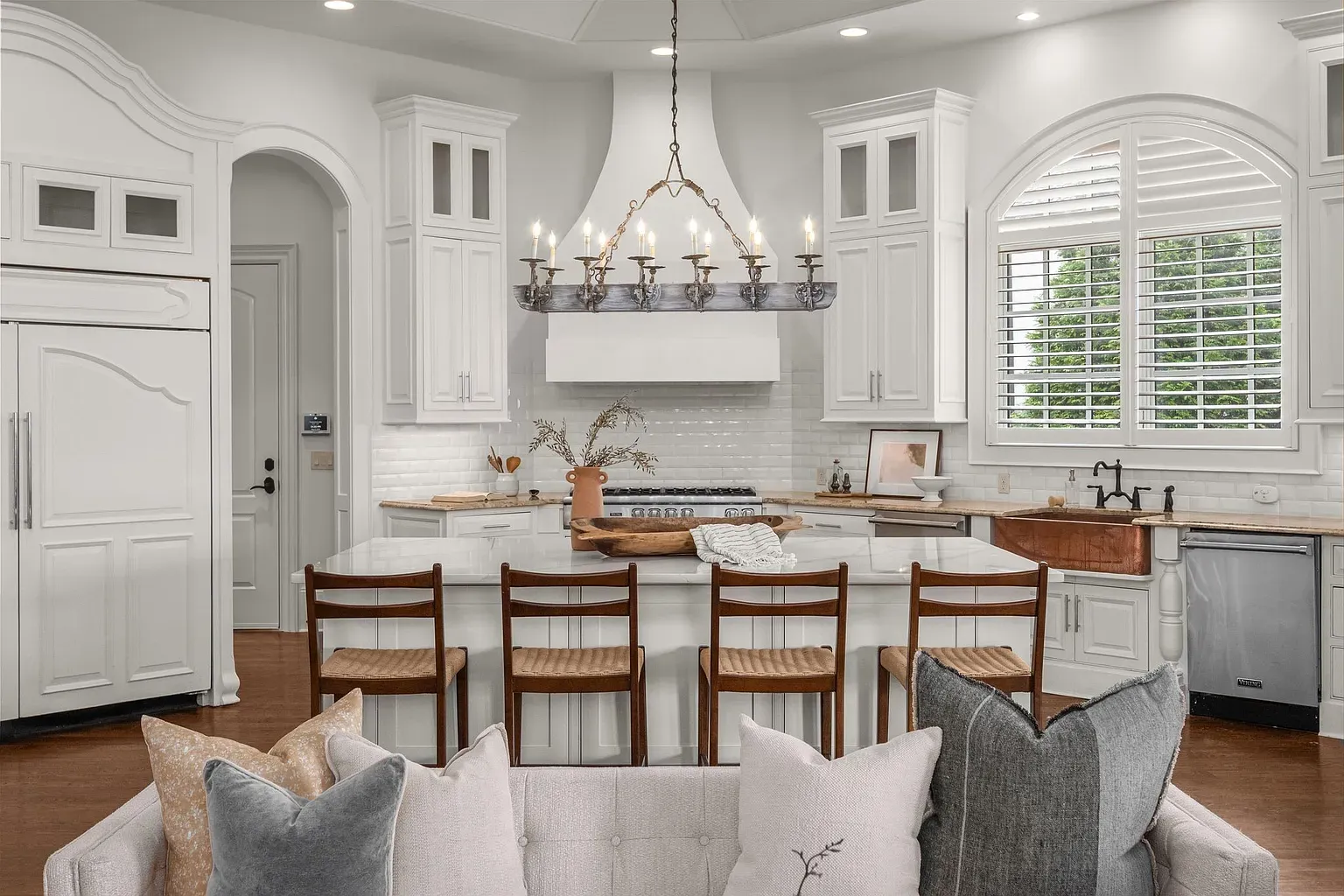 White kitchen with glass uppers and a big island. Little bit rustic.