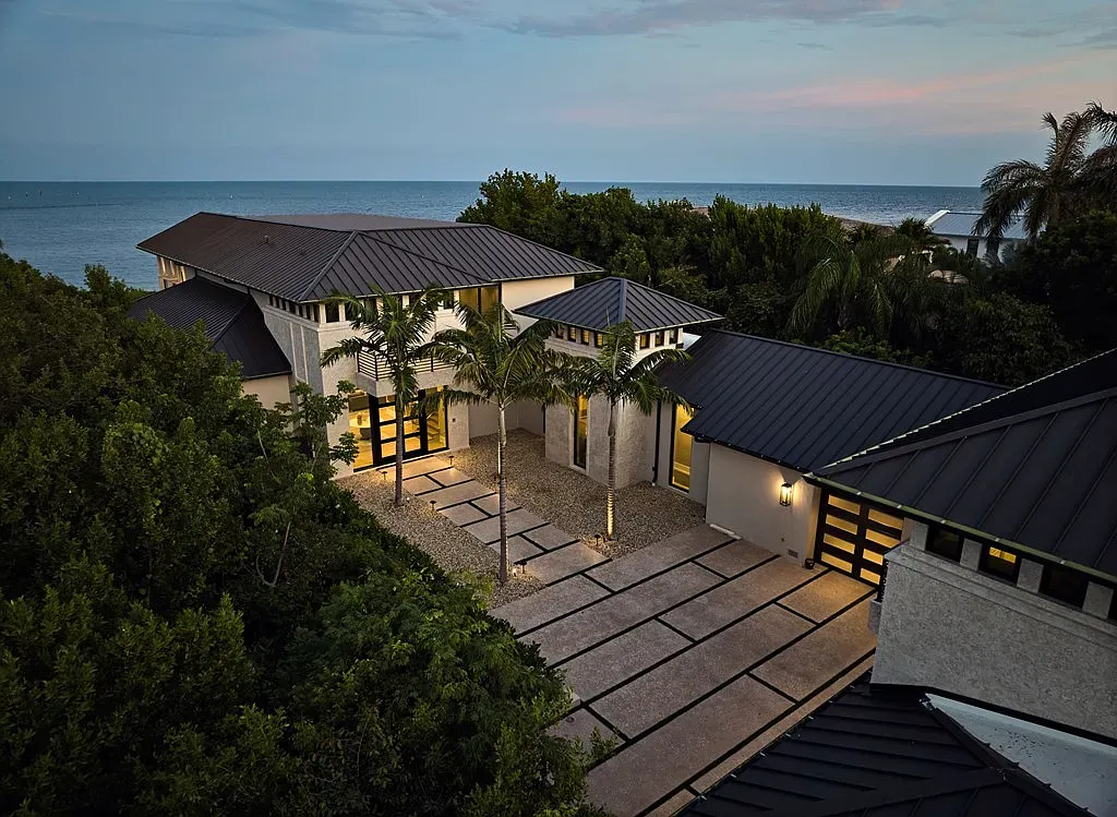 Front elevation with stucco and dark metal accents. Landscaping really frames it.