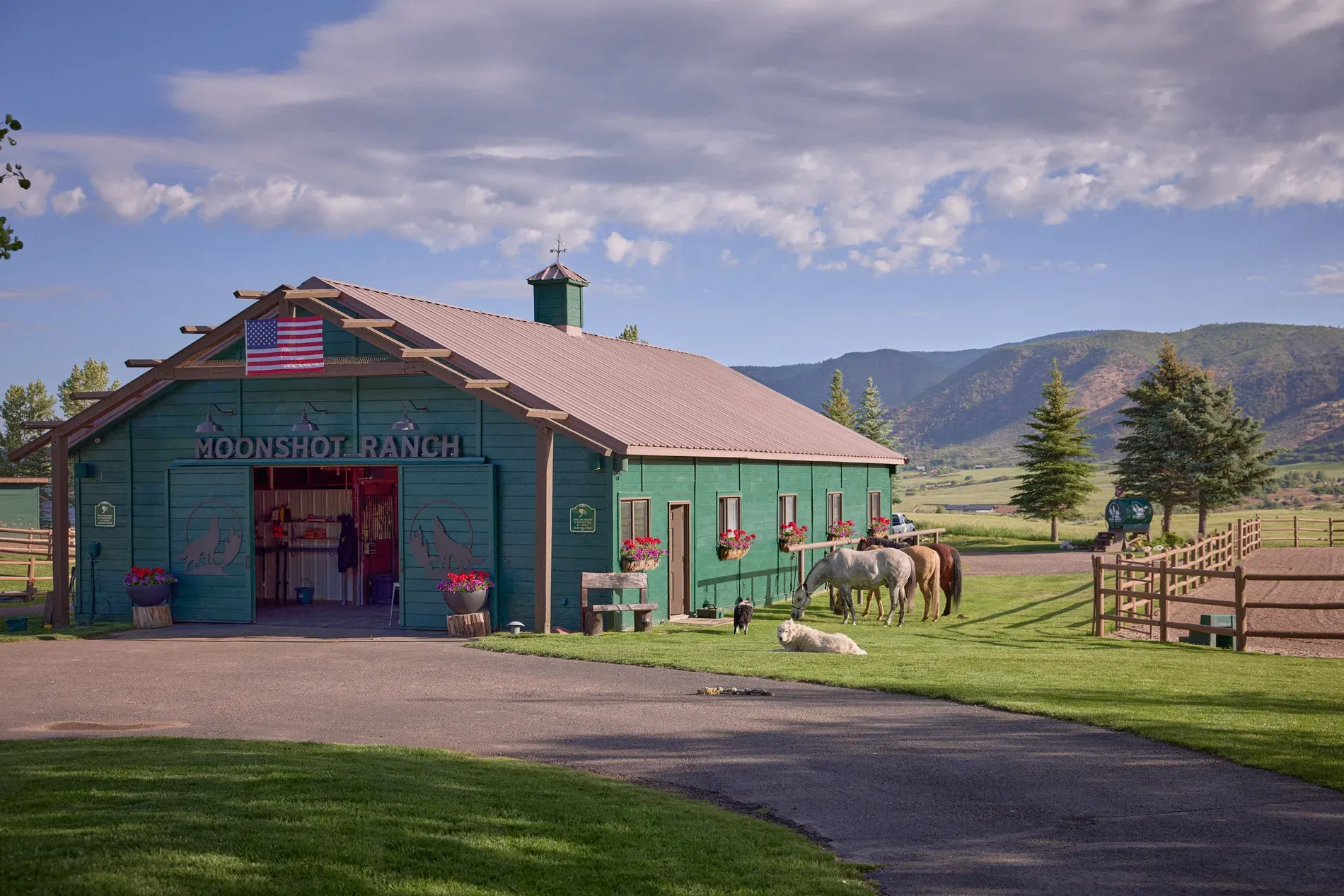 Moonshot Ranch barn — bright green, little cupola, flag on the door.