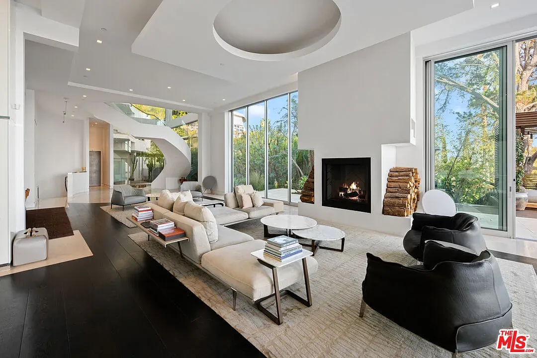 Living room is all windows and light. Soft colors, green view takes over.