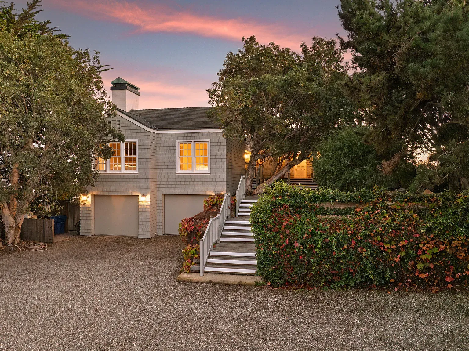 Twilight shot works. Windows glowing, gables sharp, gray shingles look perfect here.