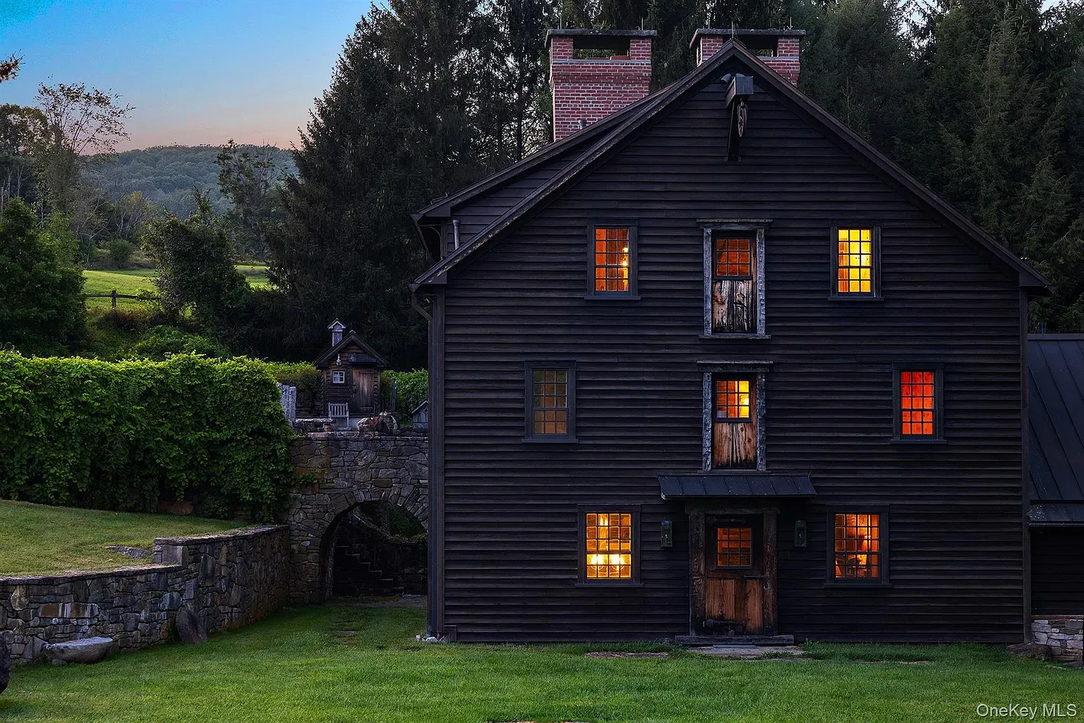 Back outside. weathered planks, tall roof, four chimneys flexing. Big statement.