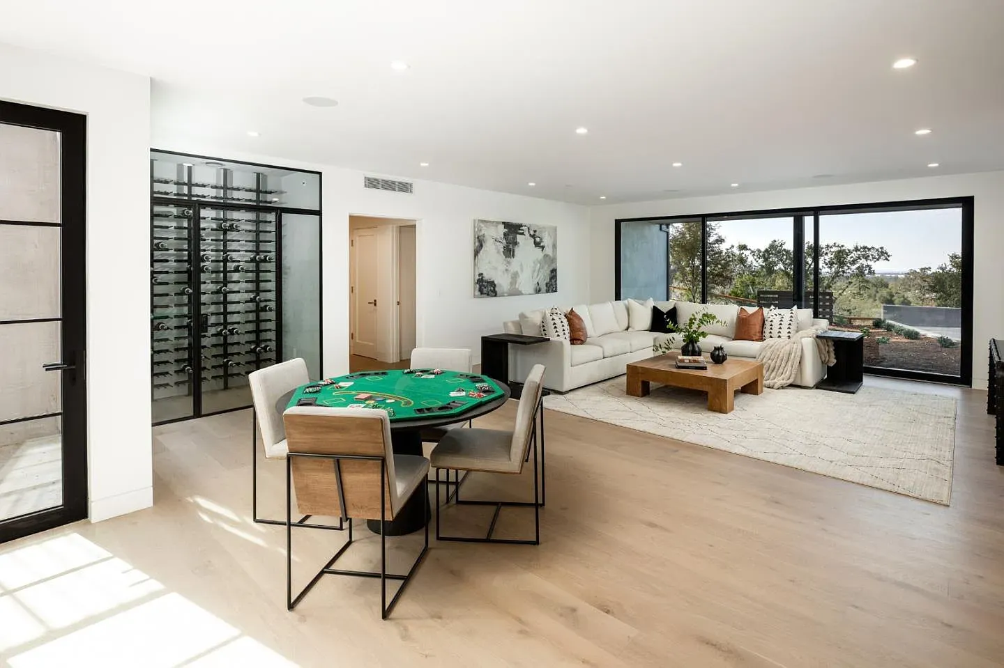 Poker table anchoring the game room. Light floors, ready for late nights.