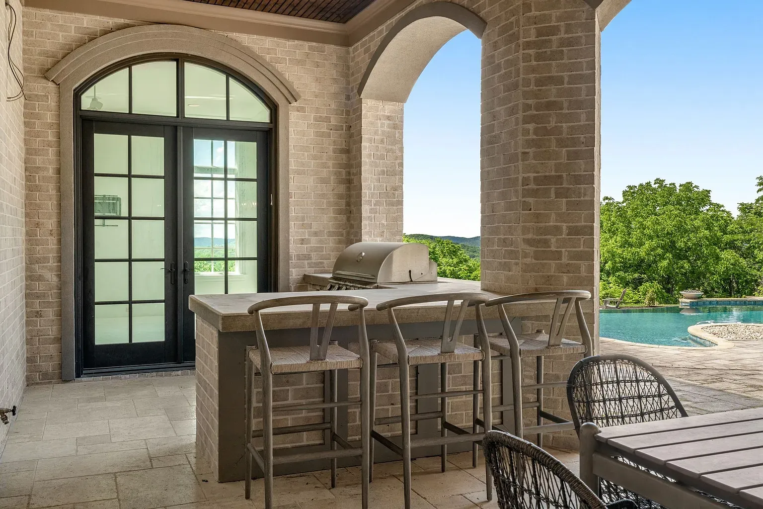 Outdoor kitchen with a stone bar. Grill boss gets a proper stage.