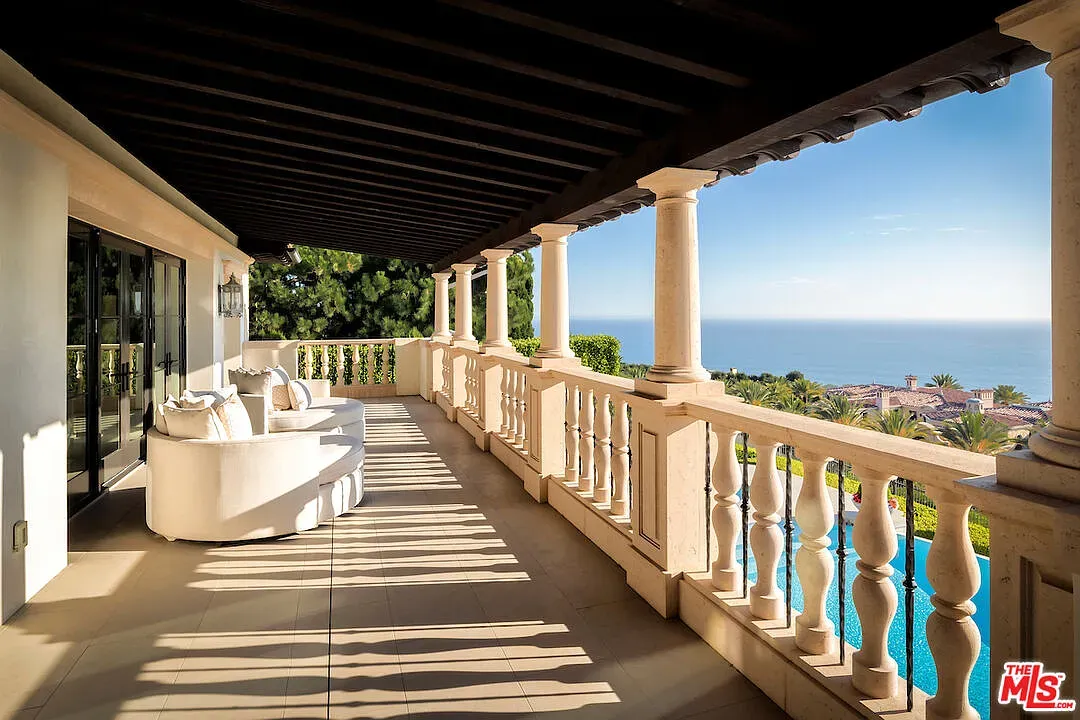 Balcony with columns, ocean for days. Coffee here, decisions get postponed.