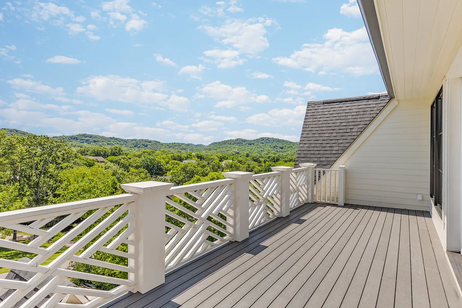Balcony with the lattice railing and the long green view.
