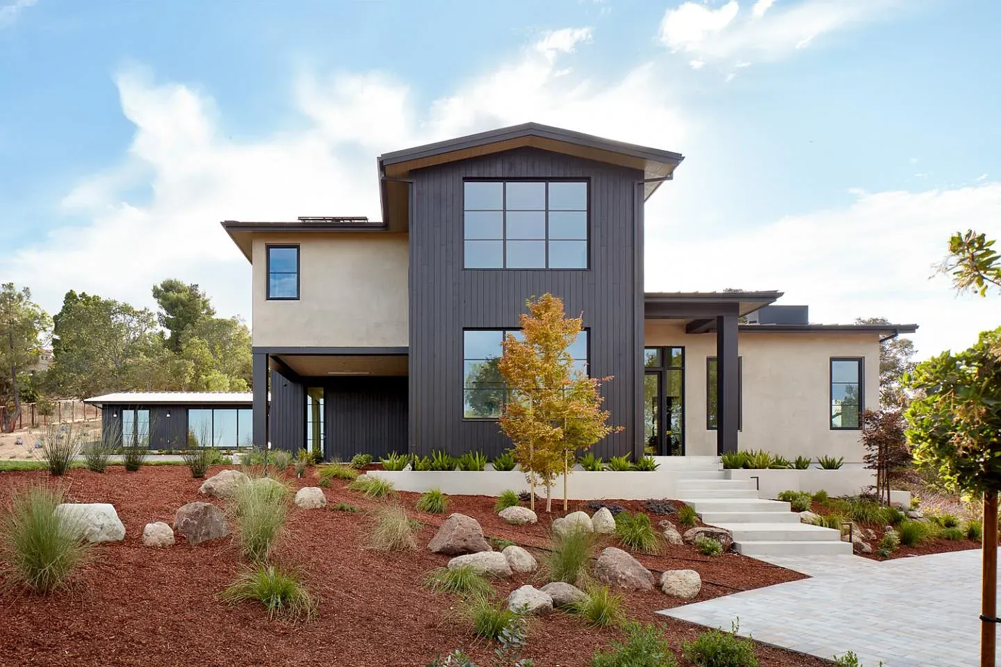 Clean lines with black siding up top and textured stucco below. Kind of dramatic.