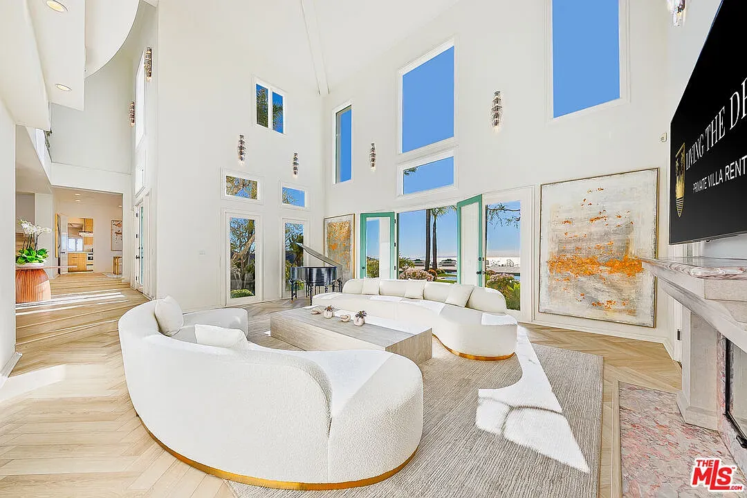 Living room is all glass and air. High ceilings, mountain views doing overtime.