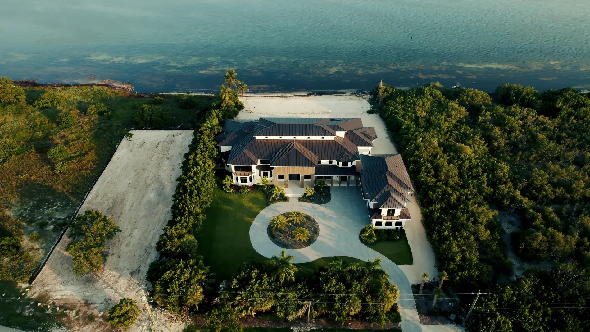 Here's the waterfront shot—huge lawn, grand modern-classic mansion just flexing.