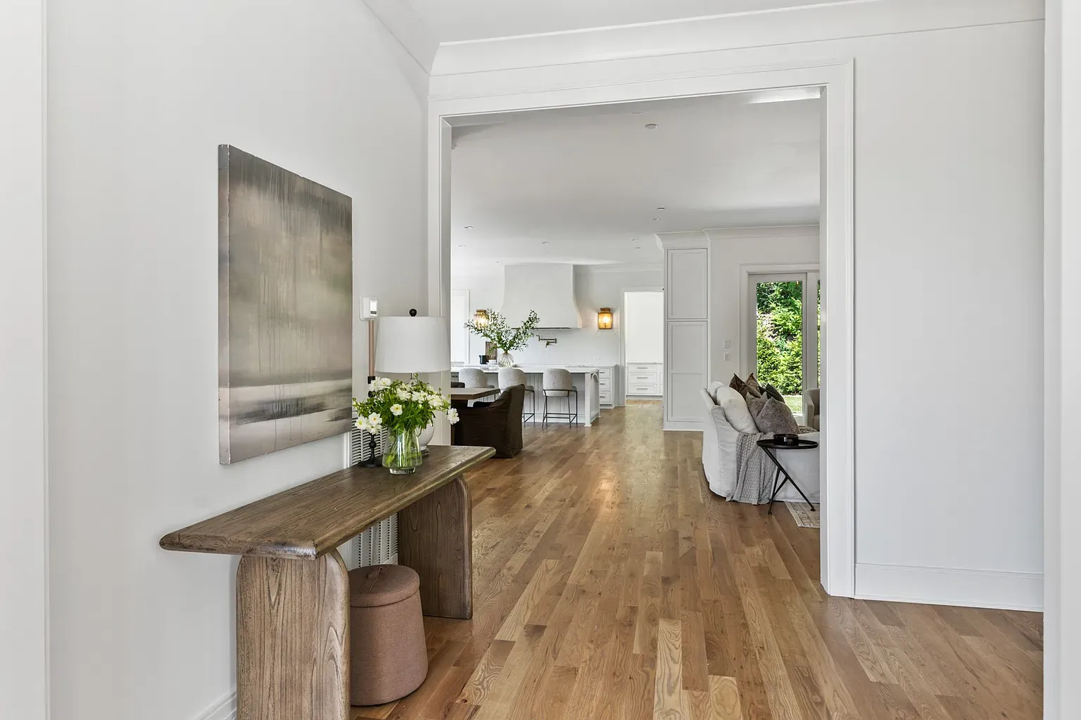 Calm entry. Light wood, soft whites, one quiet piece of art.