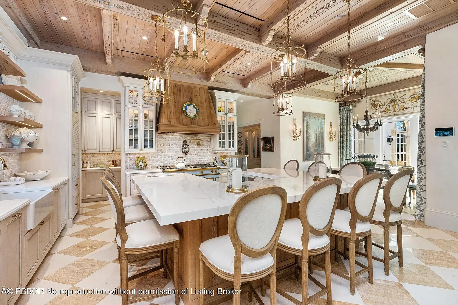 Bright kitchen island with white quartz. Stools look comfy. Where’s the mess?