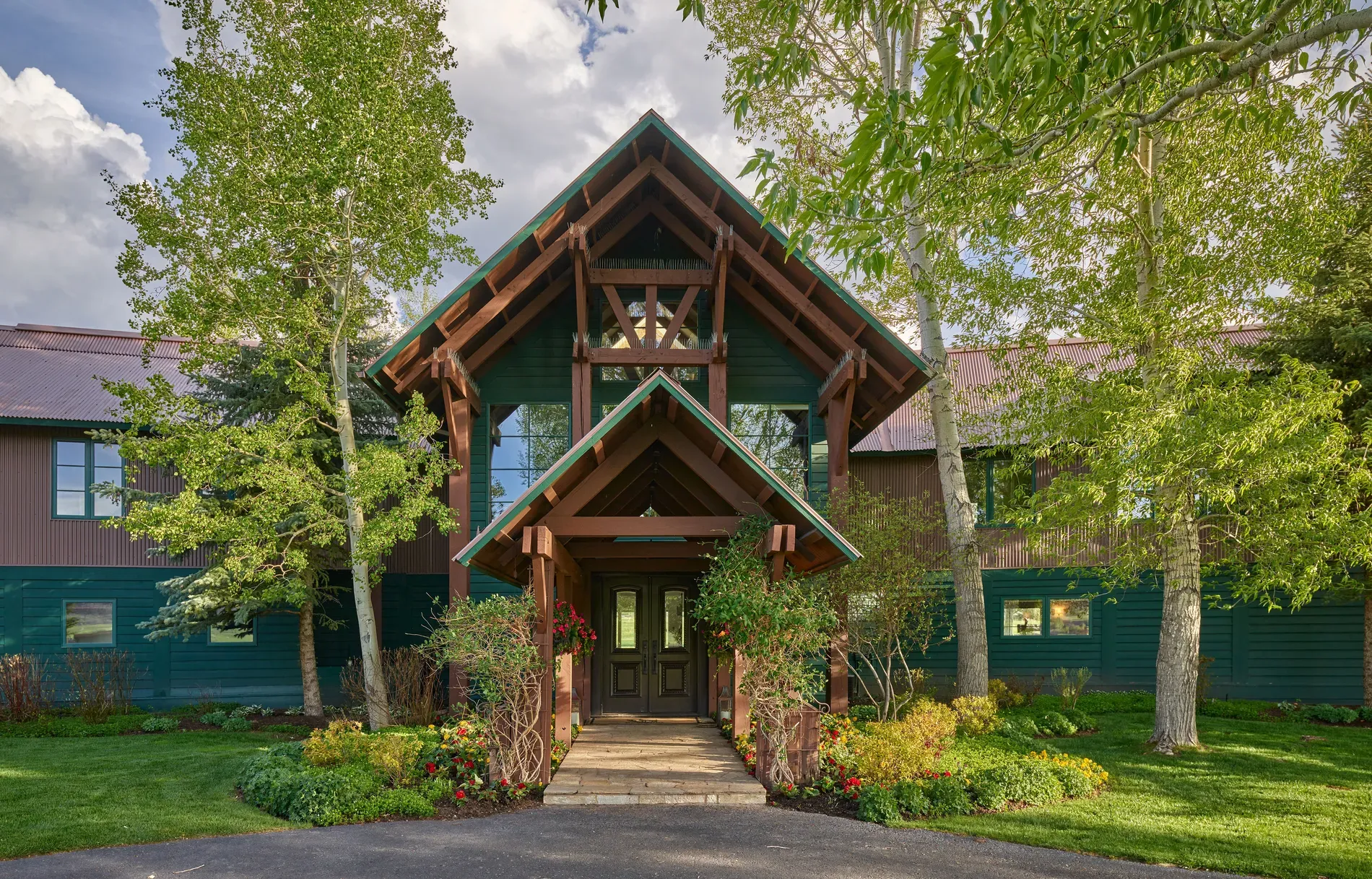 Here's the entrance — deep forest green siding, chunky brown accents. Kinda moody.