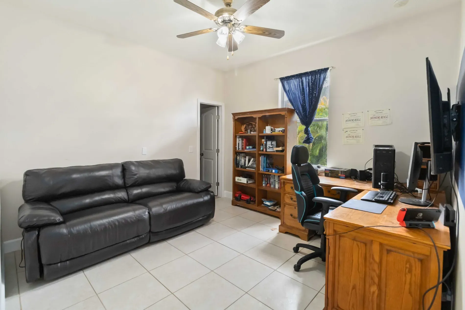 Neutral little hangout—shiny tile, wood-blade fan, chill afternoon nap spot.