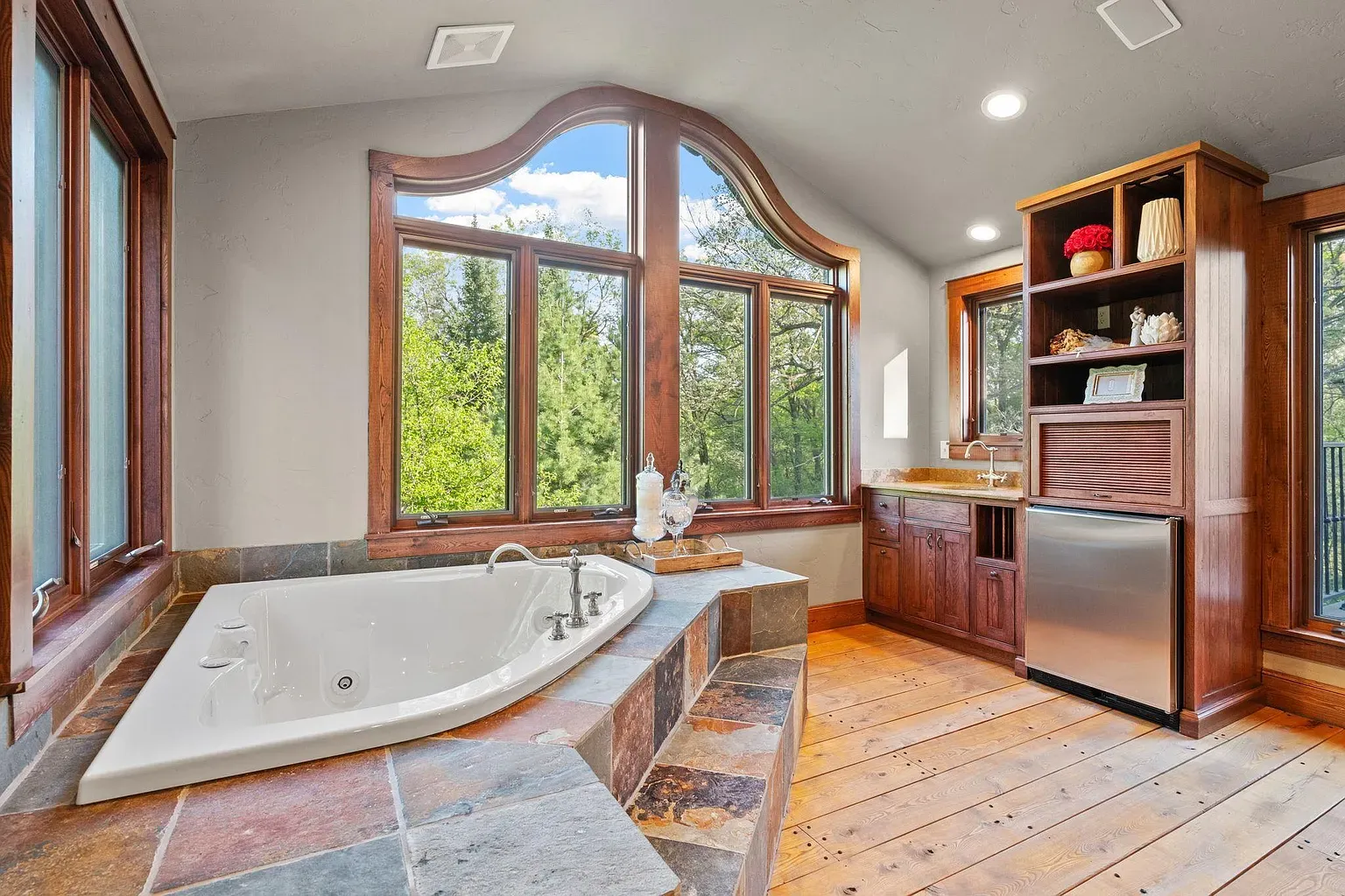 Corner jetted tub against slate - spa energy without trying too hard.