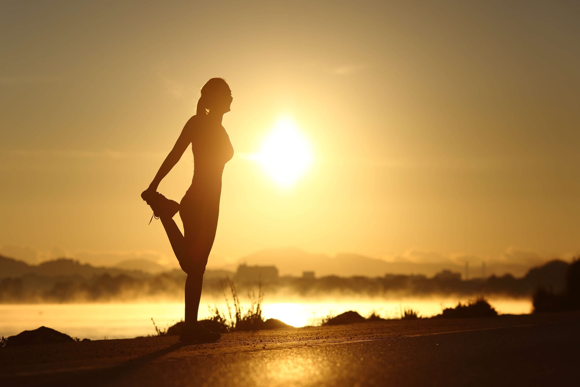 person stretching outside in the morning sun