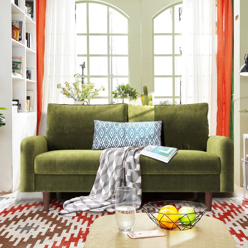 living room with apple green velvet sofa with buttonless tufting and angled legs